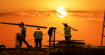 Construction workers at sunset